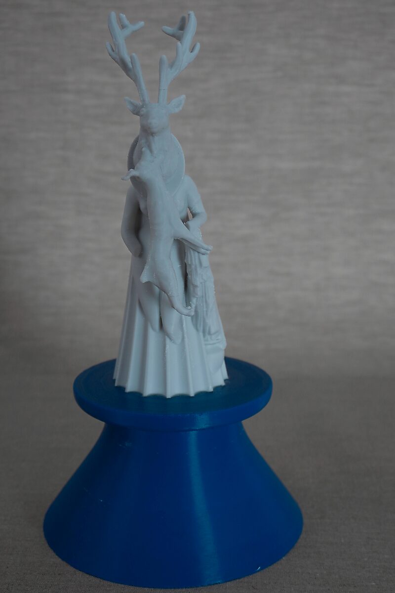 The Columns of Ovidius — Actaeon — opposite frontal view of the 3D-printed figure with a deer head and antlers, standing on a blue pedestal.