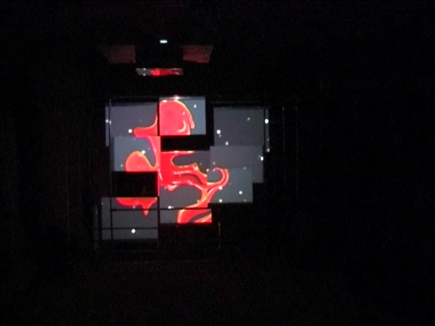 Choose and Change, Liquid Forms Through Space — photo of the installation: video projection of red, fluid shapes spread across multiple rectangular screen panels in a dark space.