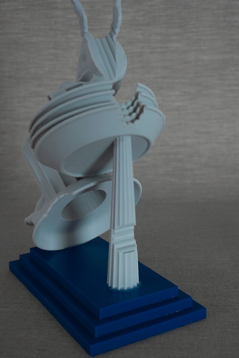 De zuilen van Ovidius — Erysichton — achteraanzicht van de sculptuur met gestapelde ringvormen, een gebroken zuil en een menselijke figuur op een blauwe sokkel.