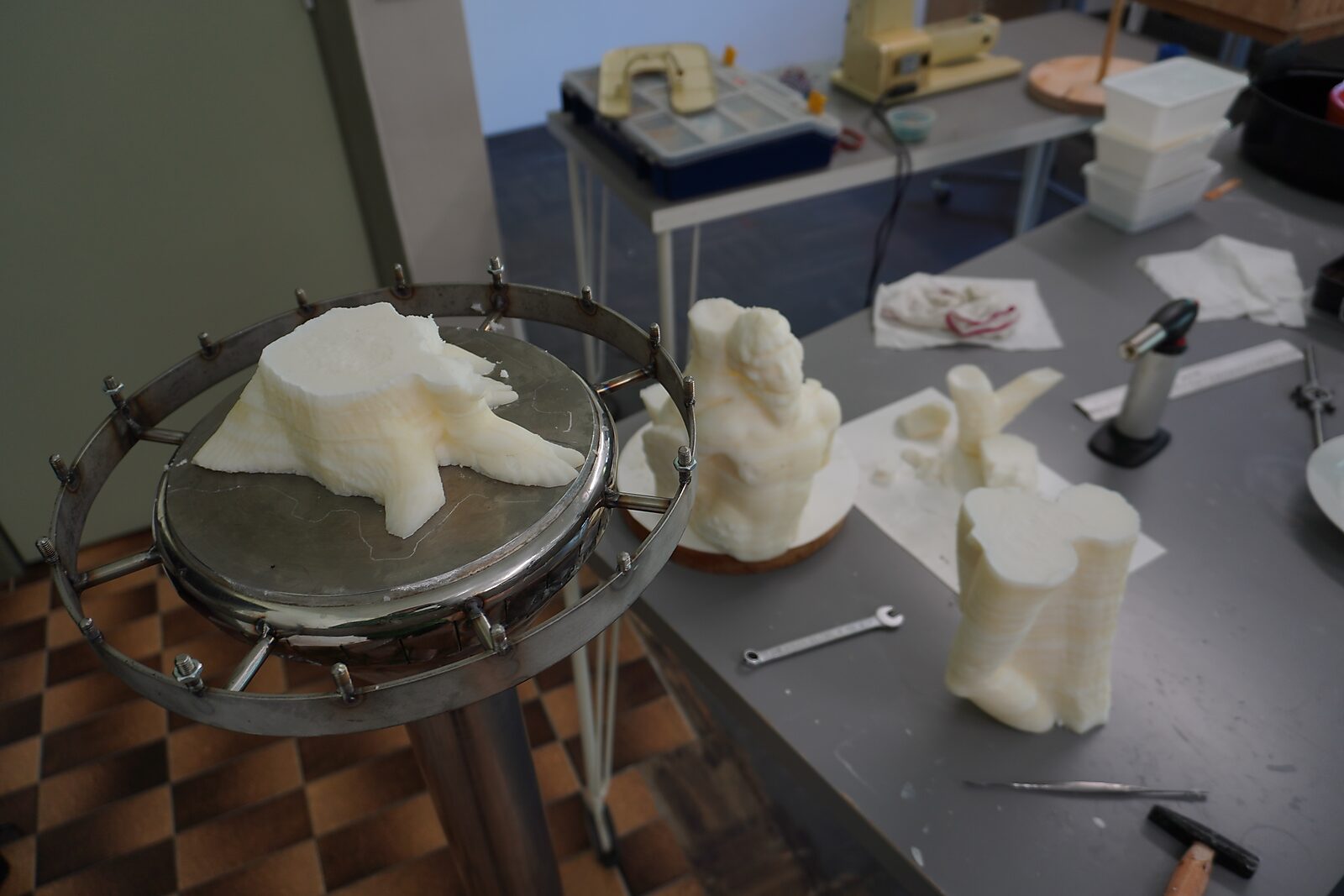 The Great Escape of Saint Sebastian — process photo: test pieces of beef fat without glass beads removed from the mold, placed on a table beside tools.