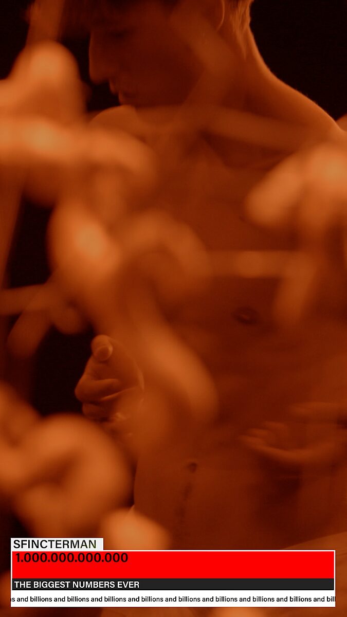 Sfincterman — videostill videowerk: een naakte danser verschijnt onscherp achter de voorgrond van organische vormen en draadstructuren.