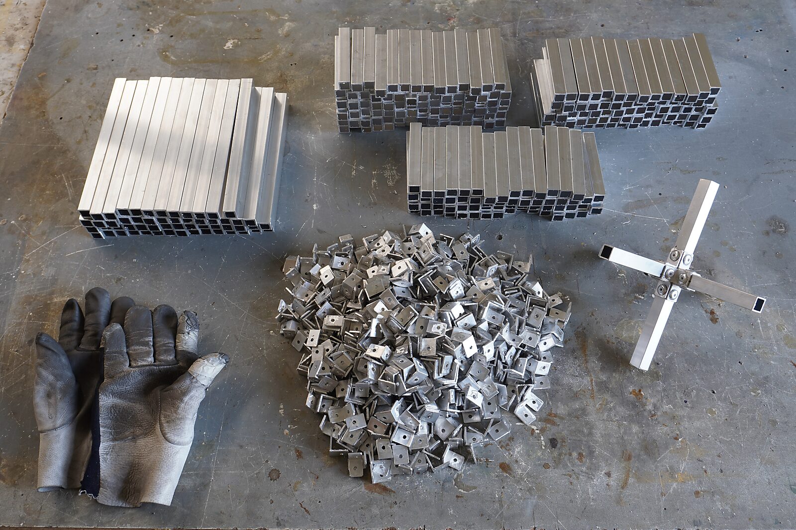Choose and Change — aluminium construction system: overview of aluminium profiles, connection pieces and gloves, with an example of cross-shaped assembly.