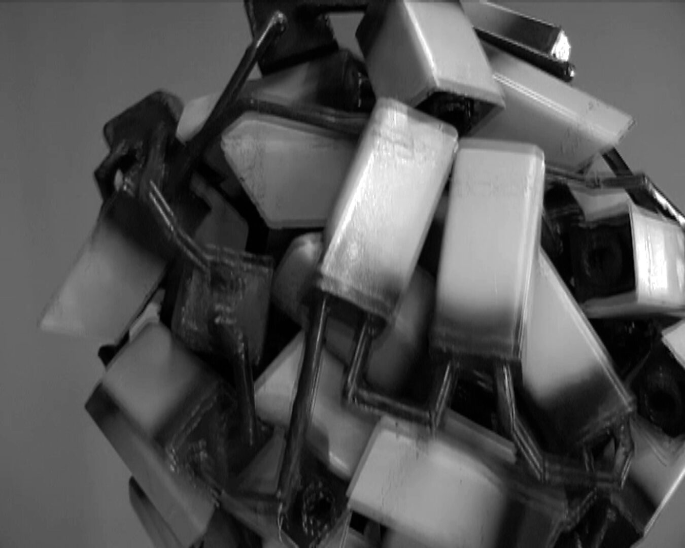 Big Brother in storing — videostill waarin de Camera bal versnelt en de individuele camera’s optisch beginnen te vervagen tot één dynamische massa van observatie.