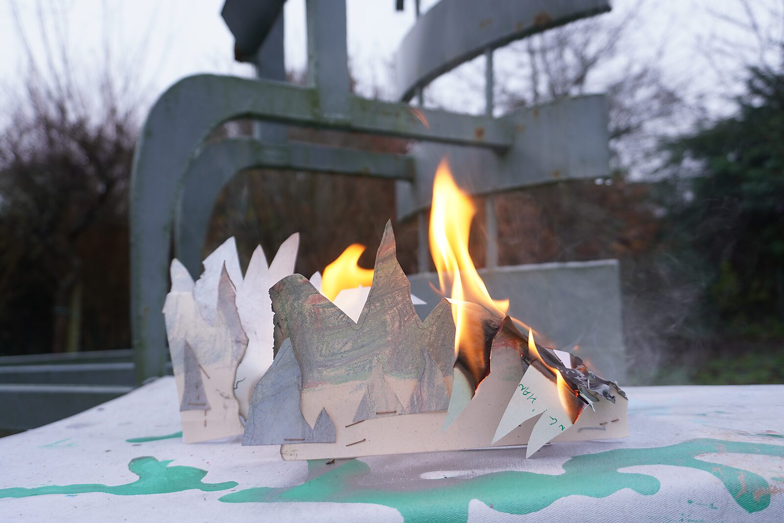 The Divider — process photo: remaining fragments of the drawings being burned outdoors.