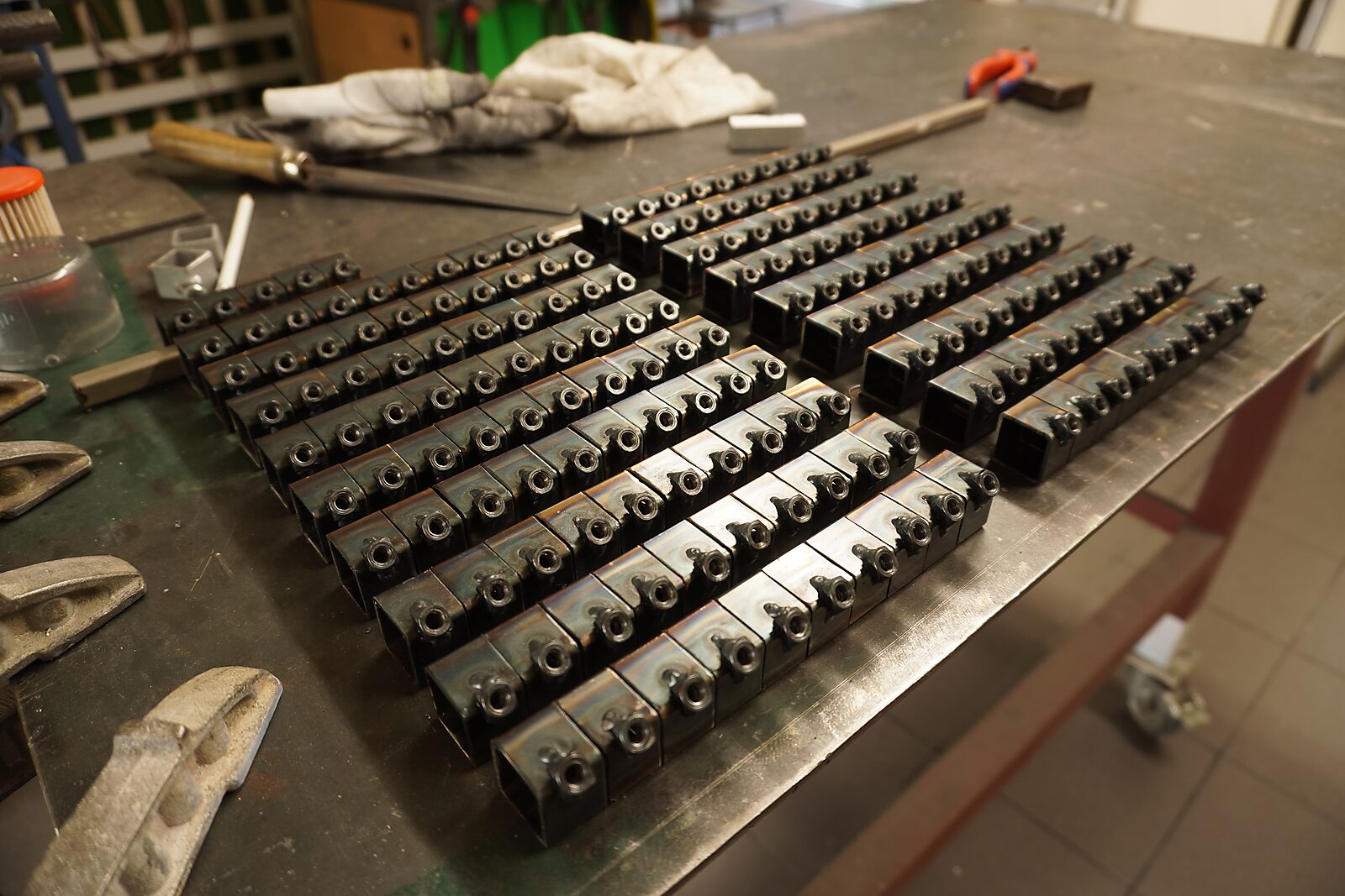 Choose and Change — aluminium construction system: worktable with rows of welded metal blocks and tools, prepared for assembling connection pieces.