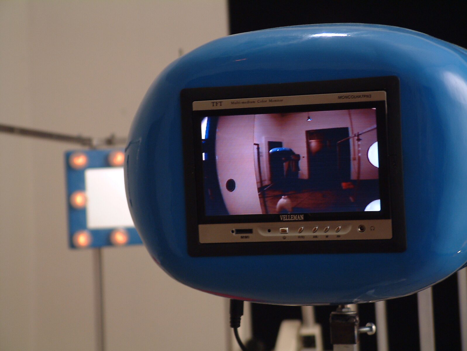 Kies en verander, Installatie voor een egoïstische rapper — foto van de installatie: blauw monitorachtig object met ingebouwd scherm toont een videobeeld van de installatie.