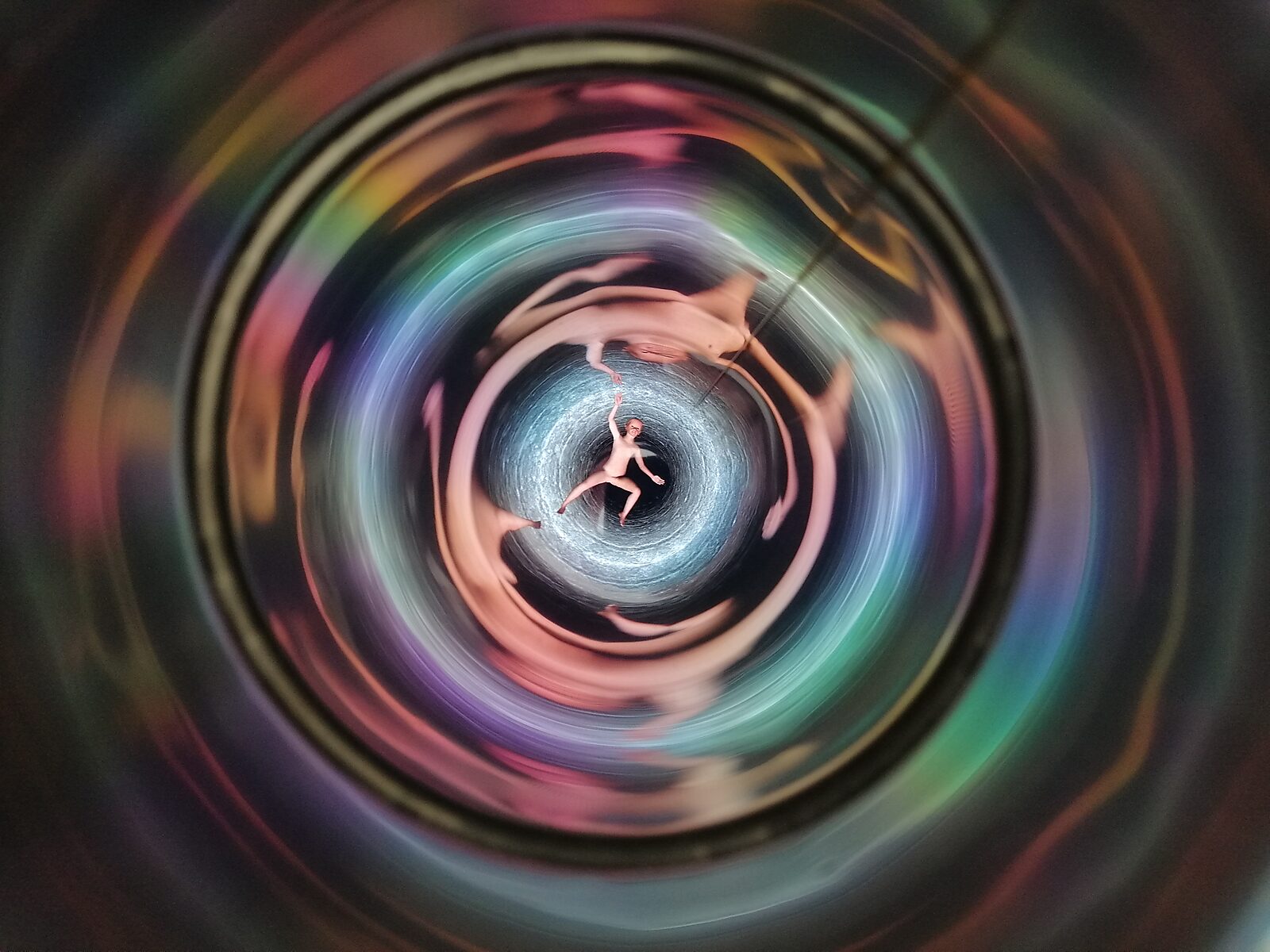 Well of Fluid Identities — straight downward perspective showing concentric motion and light reflections surrounding a small central figure.