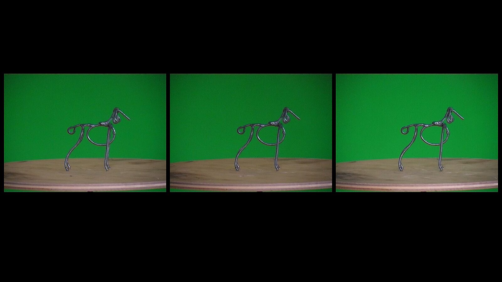 De draaihond, De veelvormige hond — videostills: ijzerdraad sculptuur van een hond op een ronde tafel tegen een groene achtergrond.