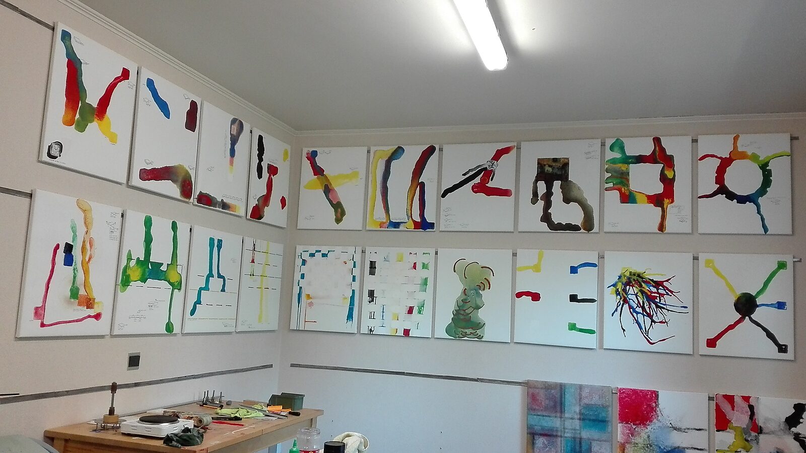 Melting Compositions — studio view of the project showing multiple paintings from the series on the walls, presenting the results of the experiment with melting colored ice plates.