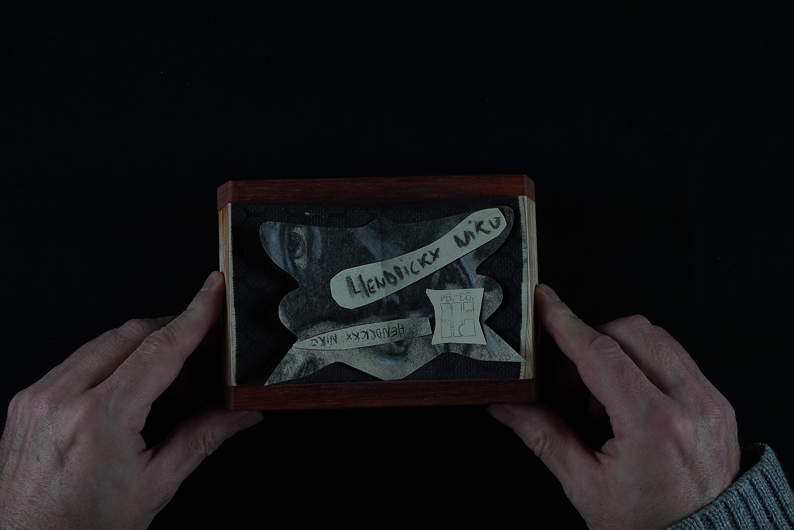 Naming–Value Butterflies — process drawing: self-portrait study 3 PHIKO (1993) — the finished naming-value butterfly with a face fragment, name strip and label lies in a small box held by two hands.