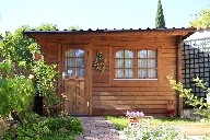 Ambiance déstressant avec un chalet en bois, un jardin, l'allée en pavés de pierre