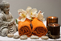 Petit bouddha et galets posés décorent la table avec les serviettes roulées