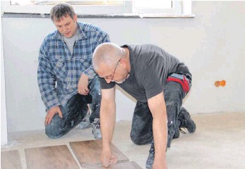 Frank Mehner (links) und Manfred Marx machen sich ans Fliesenlegen im neuen Feuerwehrhaus