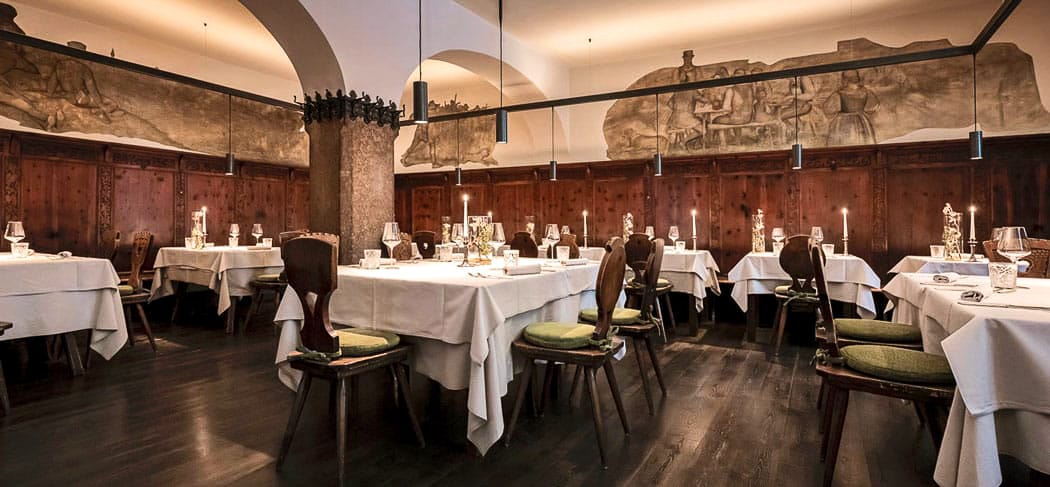 Blick in die historische Gaststube im neugotischen Stil mit Jugendstil-Kachelofen im Wirtshaus Löwengrube - Restaurant & Lounge in Bozen - Gourmet Südtirol