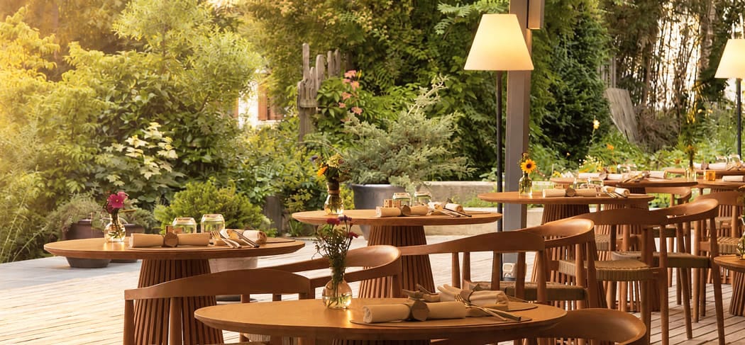 LA VIMEA Vegan Restaurant in Naturns: Stilvolle Terrasse mit Blick ins Grüne, liebevoll gedeckten Tischen und entspannter Atmosphäre für veganen Gourmetgenuss.