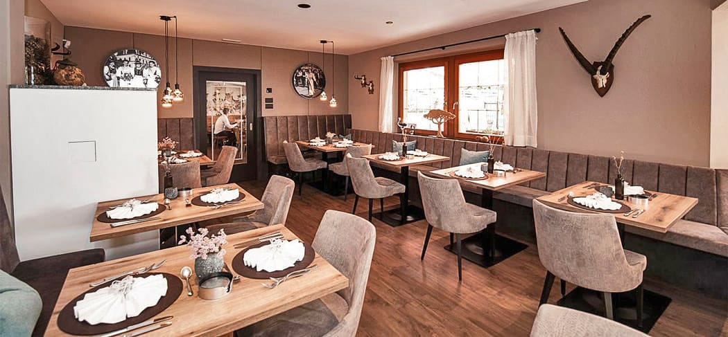 Heller, elegant gedeckter Speisesaal im Restaurant Pichler in Schenna mit Panoramablick auf die Südtiroler Bergwelt – stilvolles Ambiente für Genießer.