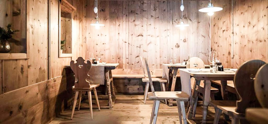 Gemütliches Fine-Dining-Ambiente im Frieda’s Restaurant im Hotel Belvedere in Jenesien – helle Zirbenstube mit Holztischen, stilvollen Details und warmem Licht.