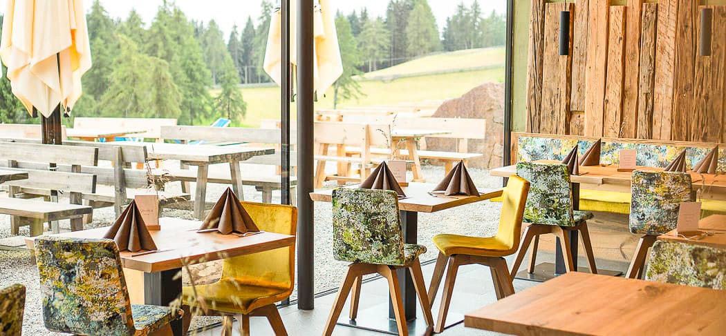 Moderne, gemütliche Einrichtung im Berggasthof Lanzenschuster in Jenesien, mit Blick auf die Weiten des Tschögglbergs und warmen, natürlichen Holztönen.