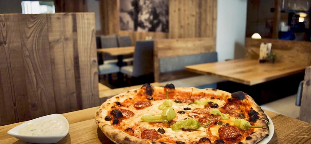 Ofenfrische Pizza mit Salami und Peperoni in Luisl’s Keller Pizzeria in Meran, Südtirol.