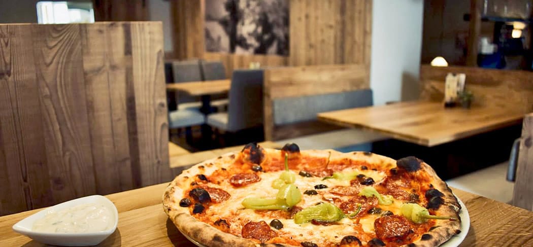 Ofenfrische Pizza mit Salami und Peperoni in Luisl’s Keller Pizzeria in Meran, Südtirol.