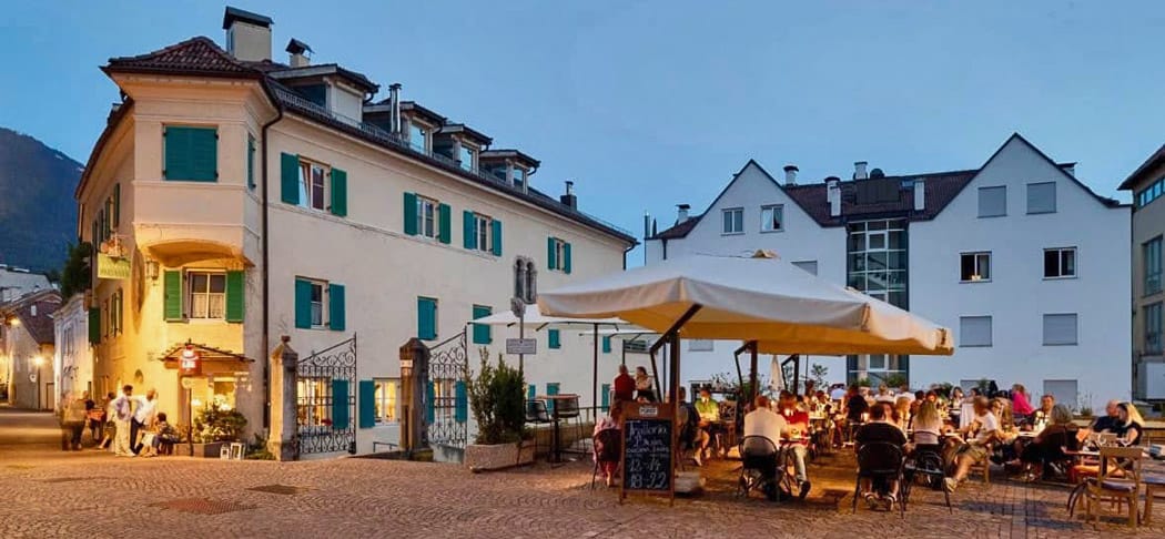 Trattoria Al Boia a Merano con un'accogliente atmosfera serale sulla terrazza.