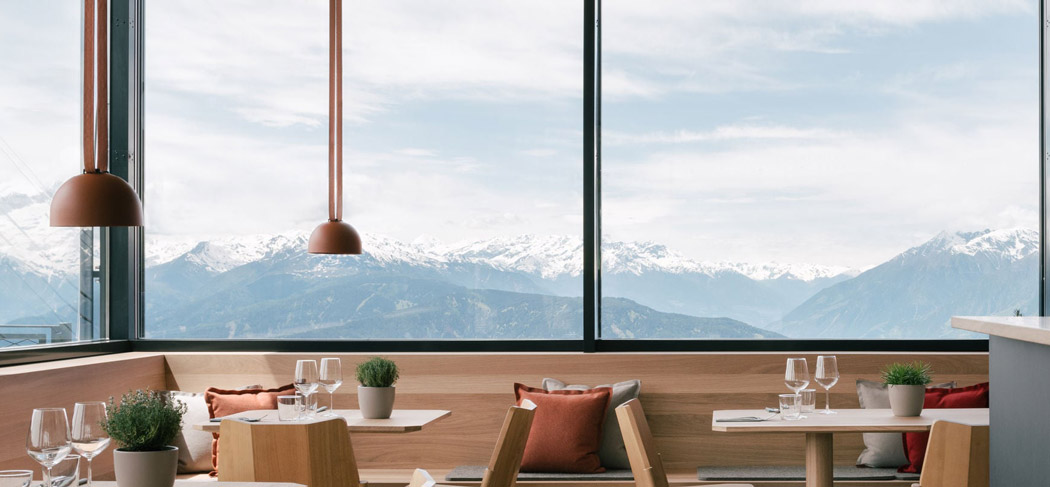 Modernes Restaurant CUBUS auf Meran 2000 mit Panoramafenstern, stilvollem Ambiente und beeindruckendem Blick auf die Südtiroler Bergwelt.