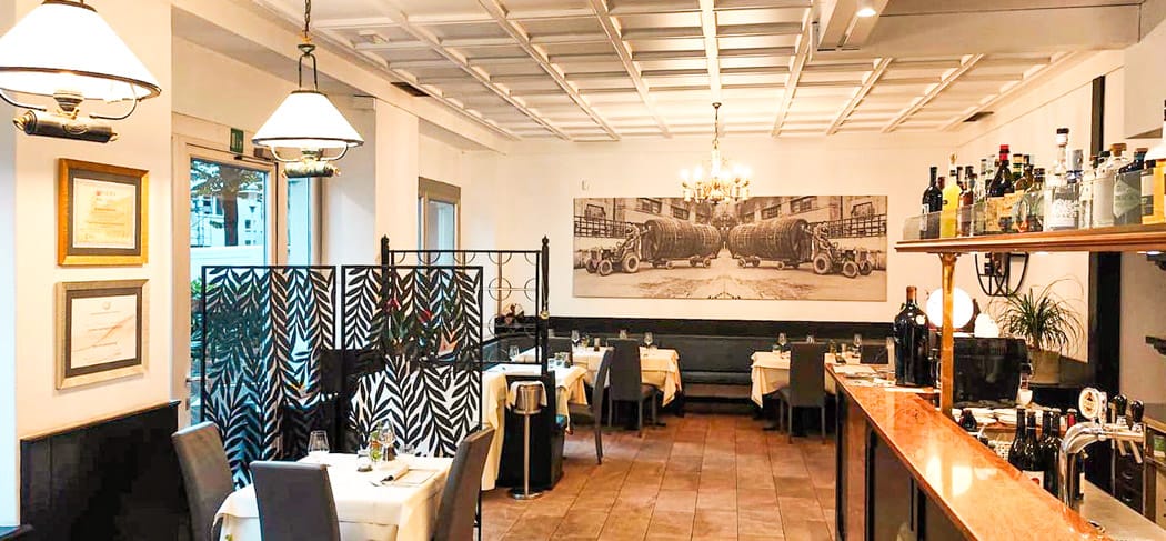 Eleganter Gastraum im Primus Garden Bistrot in Meran mit gedeckten Tischen, stilvoller Bar, warmem Licht und moderner Einrichtung für mediterranen Restaurantgenuss.