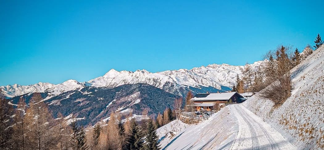 Winterliche Prantneralm oberhalb von Sterzing in Südtirol, umgeben von verschneiten Bergen, klarer Winterluft und atemberaubendem Panoramablick auf die Stubaier Alpen.