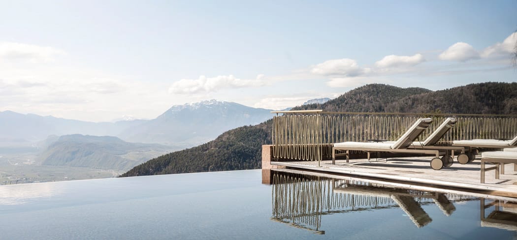 Piscina a sfioro dell'Hotel Belvedere a San Genesio con vista panoramica sulla Valle dell'Adige e sulle Dolomiti: tranquillità, sole e relax sopra i tetti di Bolzano.