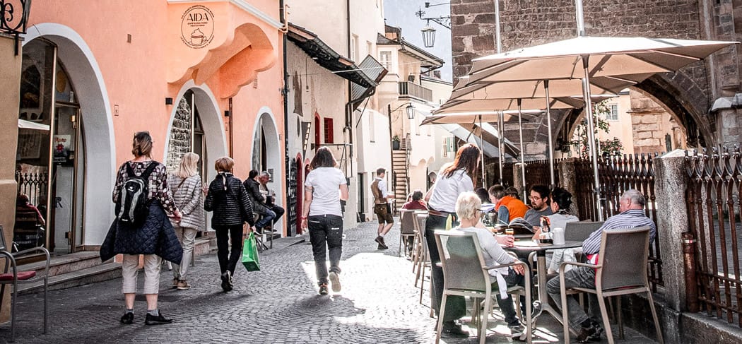Café Aida Merano: storico caffè in Piazza Duomo con un'accogliente terrazza, circondato da vicoli stretti, ideale per un caffè, una fetta di torta e un aperitivo nel centro storico.