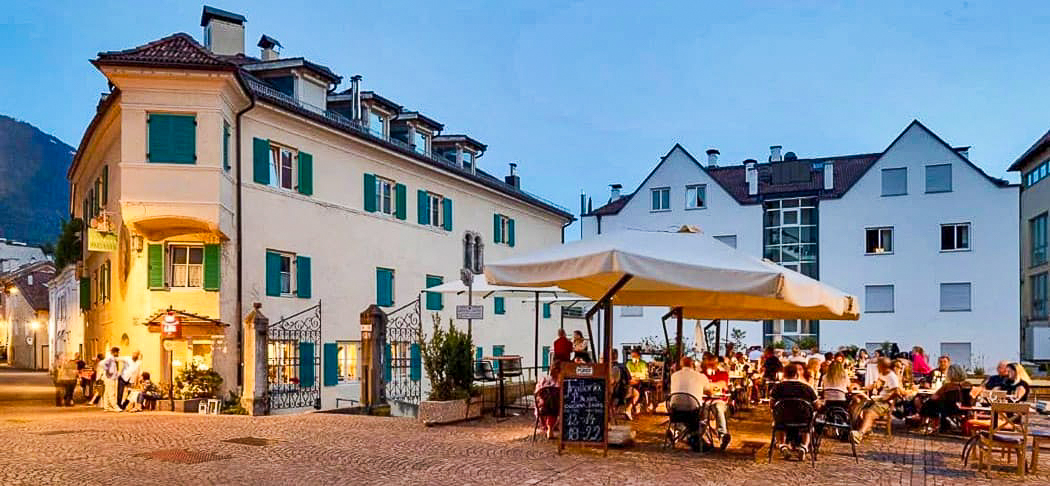Trattoria Al Boia in Meran mit gemütlicher Abendstimmung auf der Terrasse.
