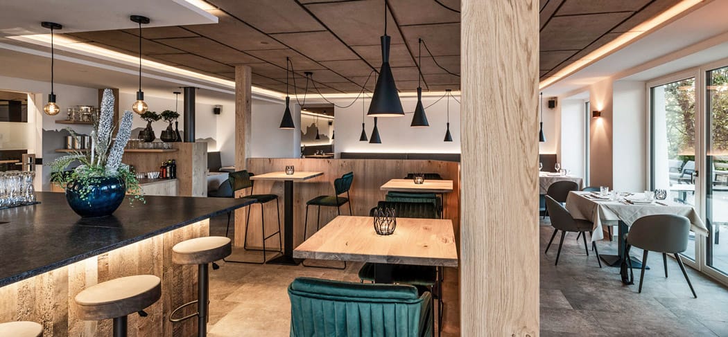 Modernes Restaurant im Pippo’s Mountain Lodge in Oberbozen am Ritten mit stilvollem Ambiente, Naturholz, Designleuchten und gemütlichen Sitzbereichen.