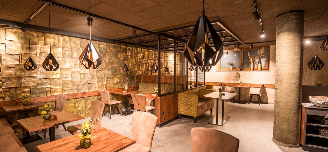 Ambiente moderno al s'Platzl Psairer Beck Bar & Bistro a San Martino in Passiria, con eleganti zone salotto, luci soffuse e un'atmosfera accogliente.