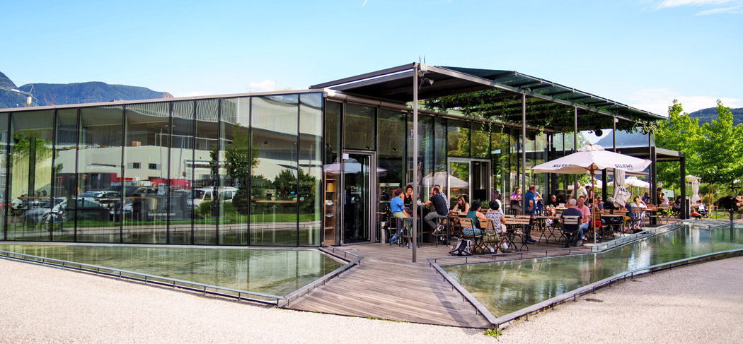 Moderno bistrot Salewa Bivac a Bolzano con terrazza e vasca d'acqua, popolare punto d'incontro per la cucina regionale e gli eventi estivi all'aperto.