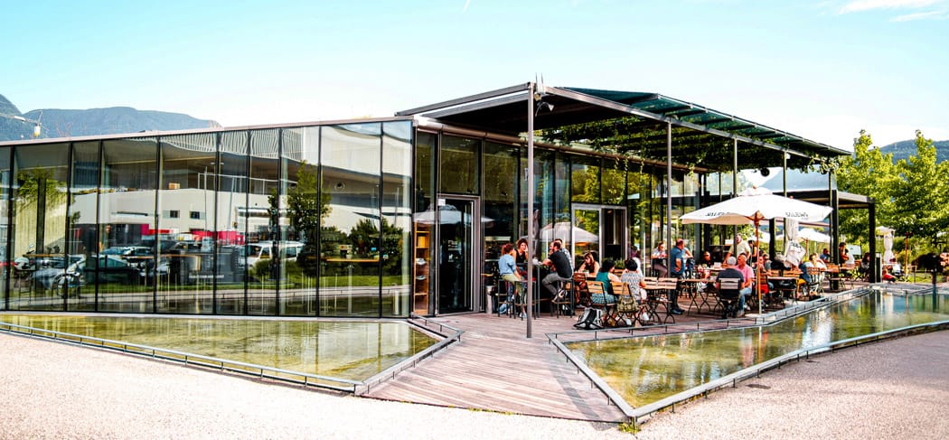 Moderno bistrot Salewa Bivac a Bolzano con terrazza e vasca d'acqua, popolare punto d'incontro per la cucina regionale e gli eventi estivi all'aperto.
