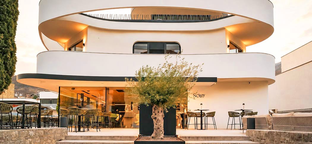 Außenansicht des Restaurants Soley in Brixen mit moderner Architektur, stilvoller Terrasse und stimmungsvoller Abendbeleuchtung.