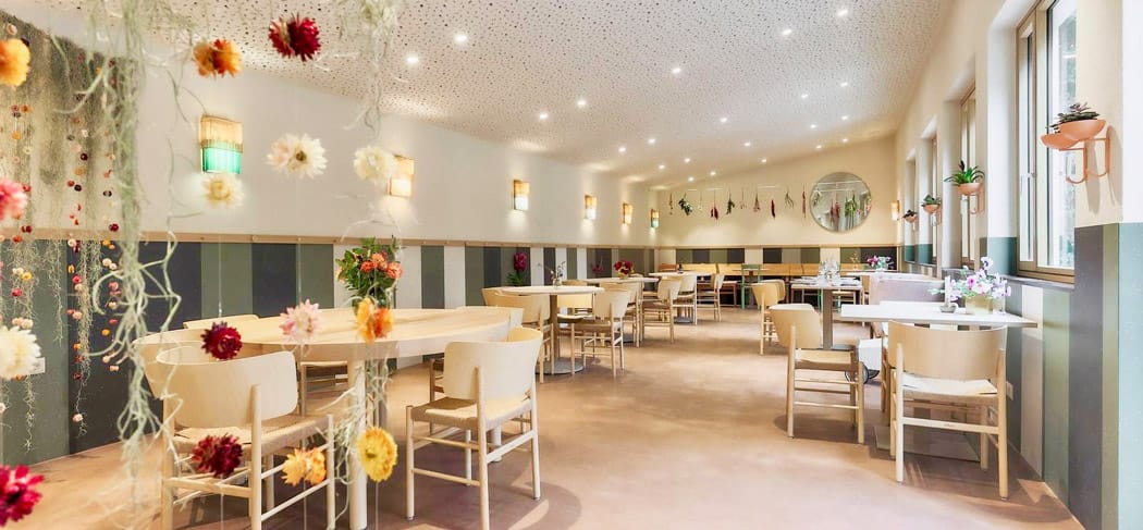 Ristorante luminoso e moderno con decorazioni floreali a Bolzano – Alma9 Bistro all'interno.