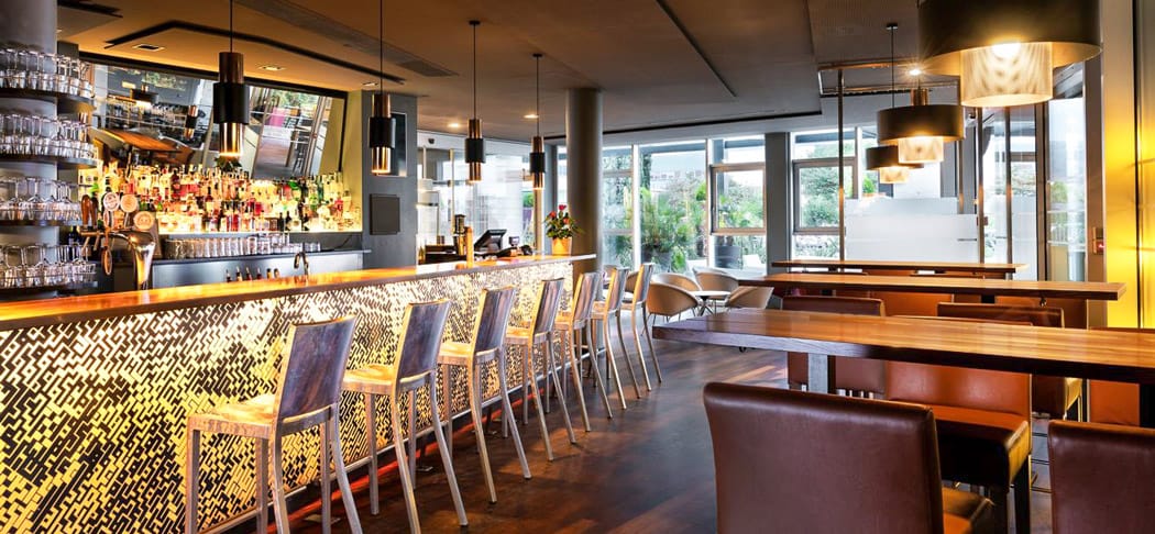 Moderne B-BAR in Bozen mit eleganter Bartheke, warmem Licht, gemütlichen Sitzbereichen und urbanem Ambiente im Four Points by Sheraton.