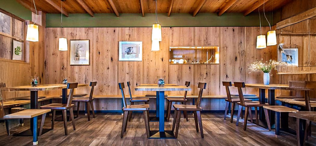 Gemütlicher Restaurantbereich im Waldrast Restaurant in Seis am Schlern mit Holzwänden, stilvoller Einrichtung, warmem Licht und modern-alpinem Ambiente.