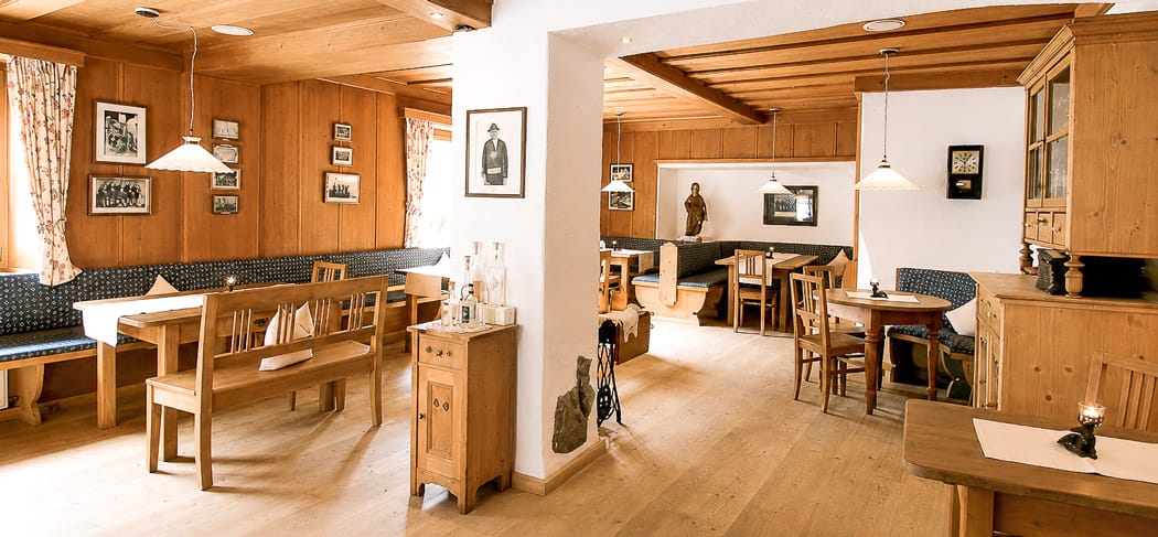 Gemütliche Holzstube im Lamm Mitterwirt in St. Martin in Passeier mit traditionellen Tischen, warmem Licht und authentischem Südtiroler Ambiente