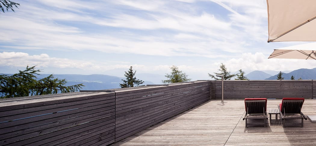 Panoramaterrasse im vigilius mountain resort am Vigiljoch mit stilvollen Liegen, ruhiger Atmosphäre und traumhaftem Blick über Südtirol.