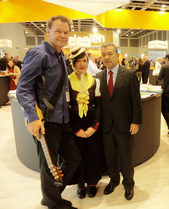 Fotogalerie © Bimbache openArt Kanarenpräsident Paulino Rivero (r.) begrüßt auf der ITB die Bimbache openART-Musiker – Gitarrist und Festivalleiter Torsten de Winkel und Sängerin Claudia Álamo aus El Hierro.