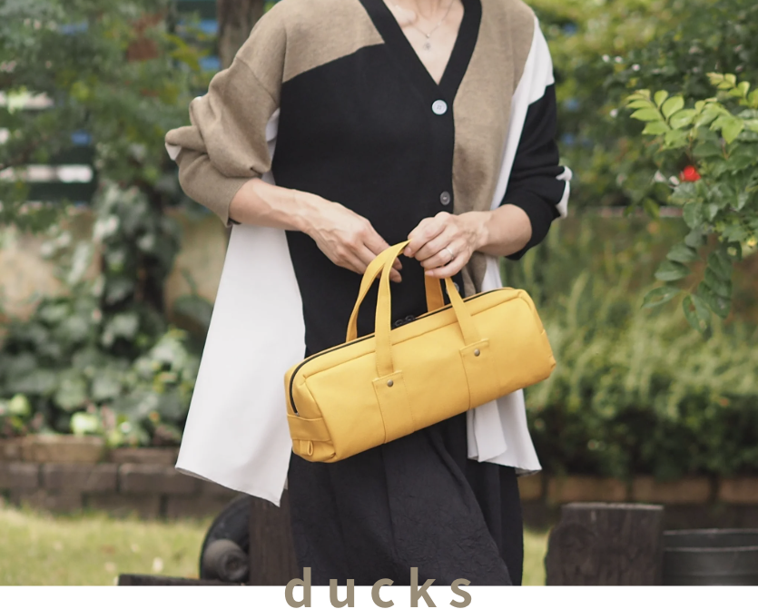 横長イエローバッグを持つ女性