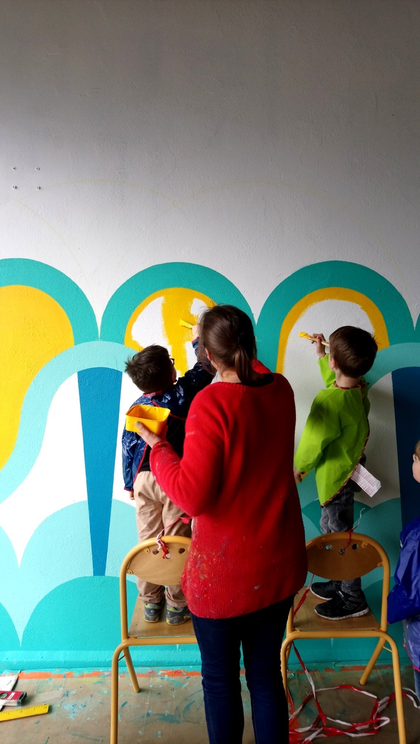 Réalisation de la peinture murale sous le préau de l'école du Moulin à Saint-Uniac. Photo : L'aparté