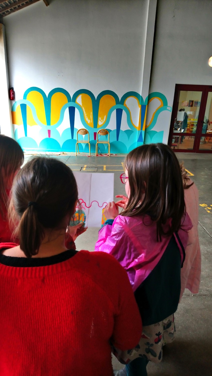 Réalisation de la peinture murale sous le préau de l'école du Moulin à Saint-Uniac. Photo : L'aparté