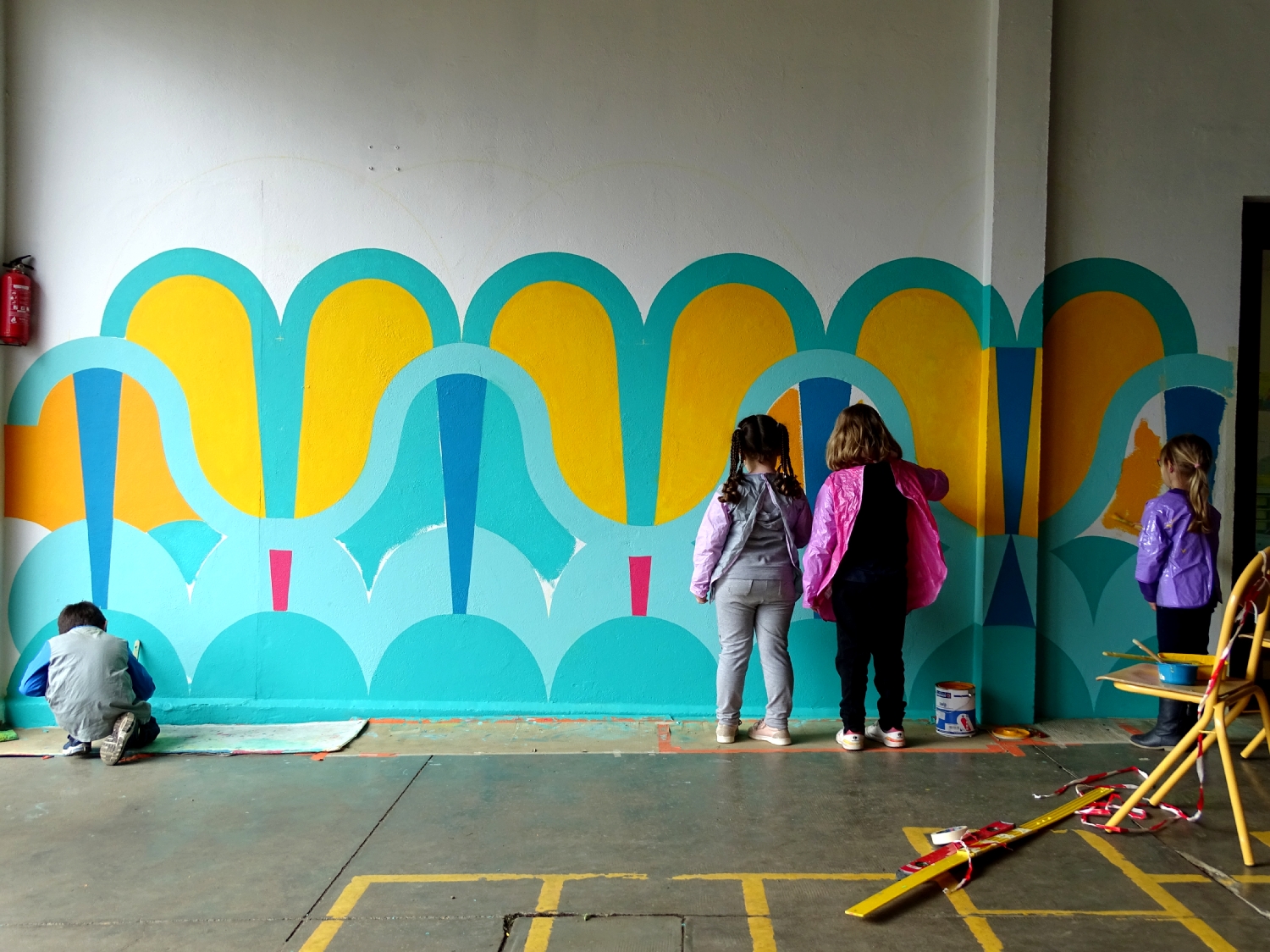 Réalisation de la peinture murale sous le préau de l'école du Moulin à Saint-Uniac. Photo : Marine Bouilloud