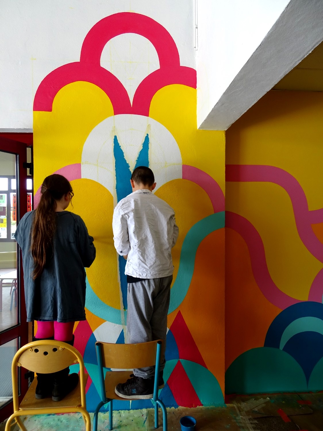 Réalisation de la peinture murale sous le préau de l'école du Moulin à Saint-Uniac. Photo : Marine Bouilloud