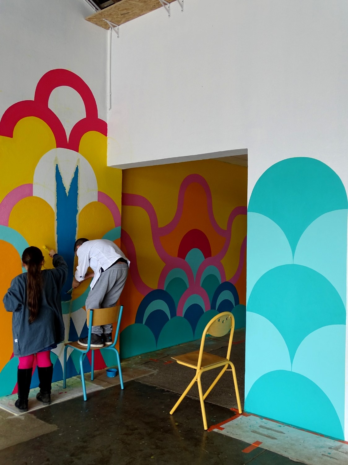 Réalisation de la peinture murale sous le préau de l'école du Moulin à Saint-Uniac. Photo : Marine Bouilloud