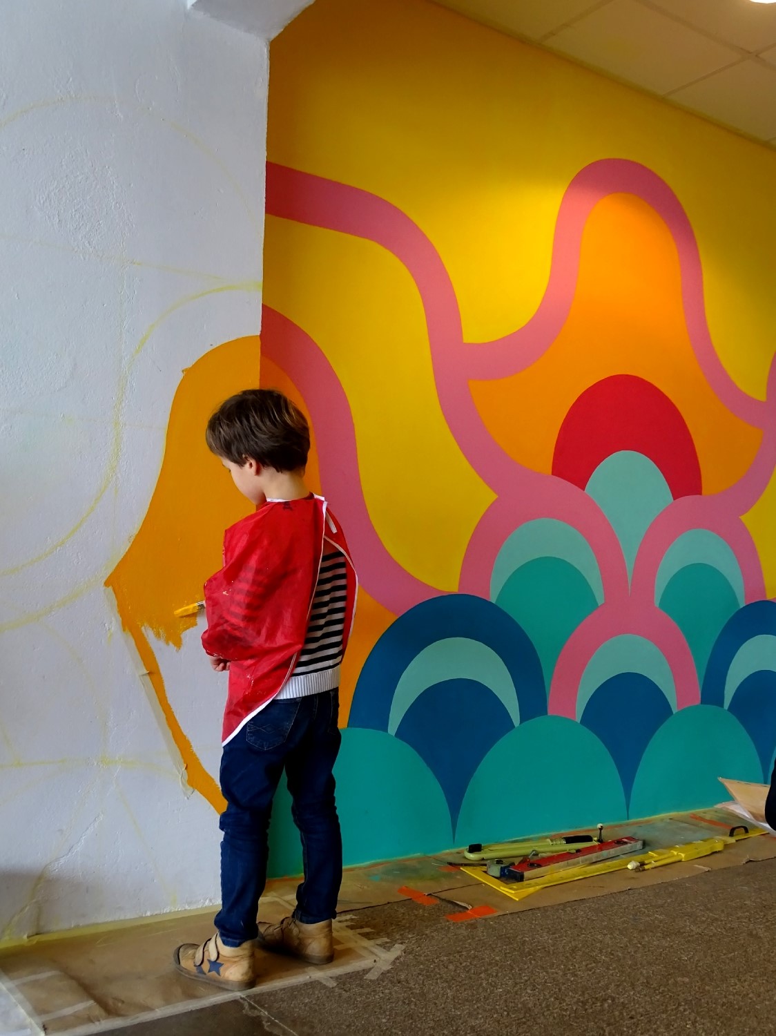 Réalisation de la peinture murale sous le préau de l'école du Moulin à Saint-Uniac. Photo : Marine Bouilloud