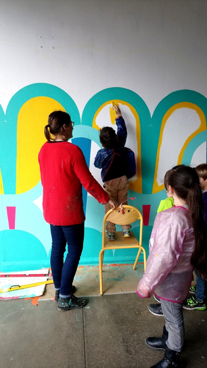 Réalisation de la peinture murale sous le préau de l'école du Moulin à Saint-Uniac. Photo : L'aparté